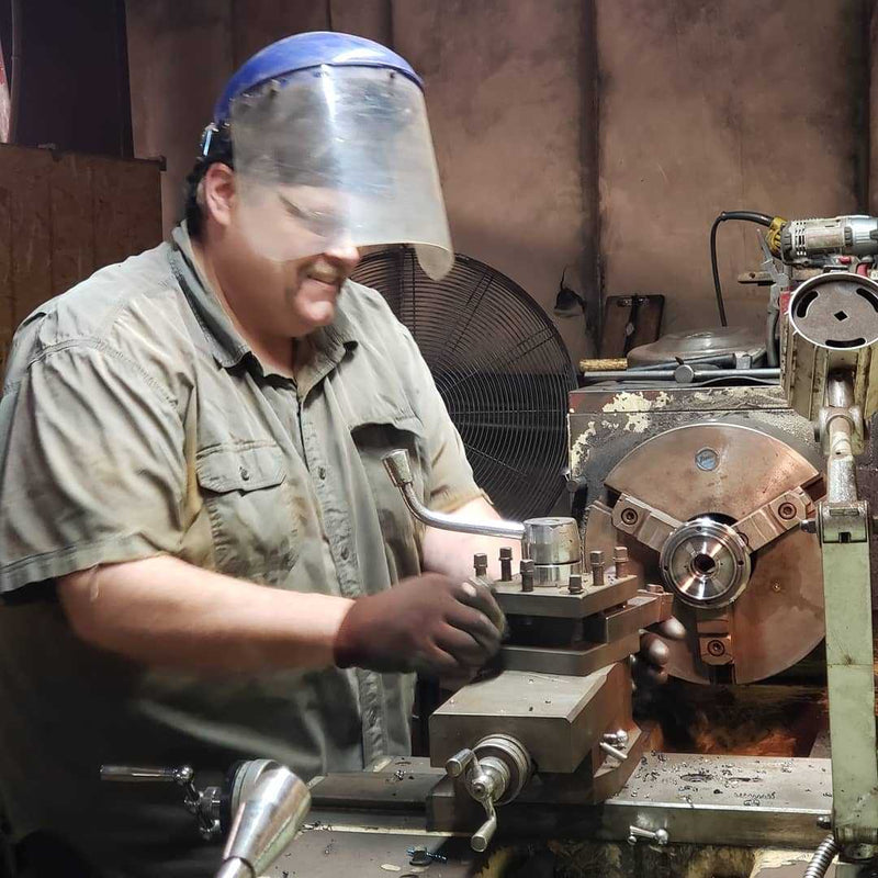 Machinist turning a torque converter component on a lathe